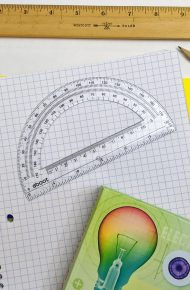 Materiale di cancelleria e strumenti di scuola vicino ad un quaderno a quadretti