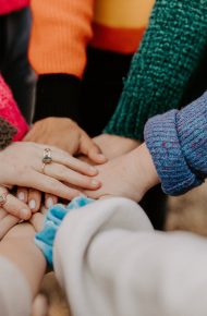 Mani unite al centro di un cerchio di persone